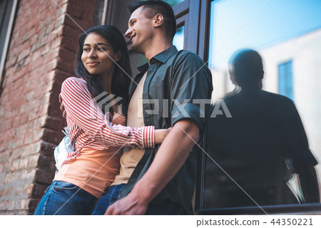 Confident woman smiling while hugging her boyfriend 44350221