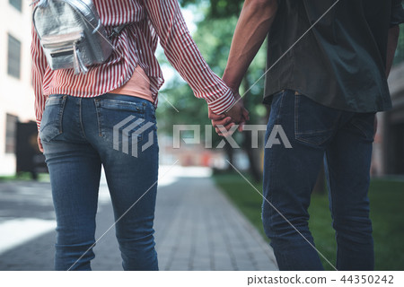 Close up of two people holding hands while being outdoors 44350242