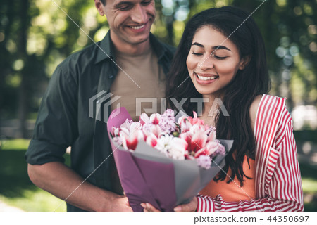 Young woman feeling happy while looking at the bouquet Young woman feeling happy while looking at the bouquet 44350697
