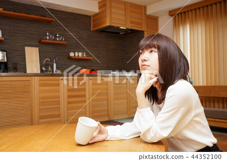 Young Japanese woman relaxing in Japanese room with tatami and shoji Young Japanese woman relaxing in Japanese room with tatami and shoji 44352100