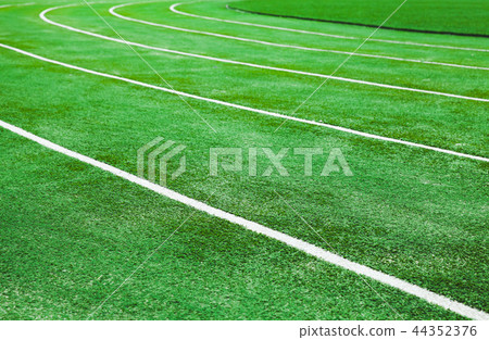 Running track with bright green artificial turf Running track with bright green artificial turf 44352376