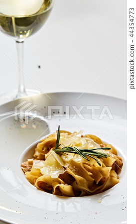 Close-up italian pasta plate with grated parmesan cheese and basil leaf Close-up italian pasta plate with grated parmesan cheese and basil leaf 44354773