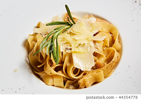 Close-up italian pasta plate with grated parmesan cheese and basil leaf 44354778