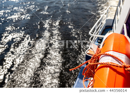 Vibrant orange lifebuoy on the excursion boat Vibrant orange lifebuoy on the excursion boat 44356014