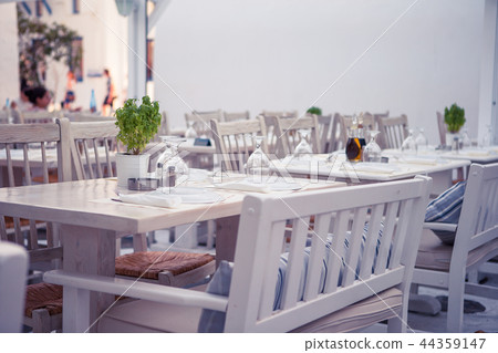 White tables with chairs at summer empty open air cafe White tables with chairs at summer empty open air cafe 44359147
