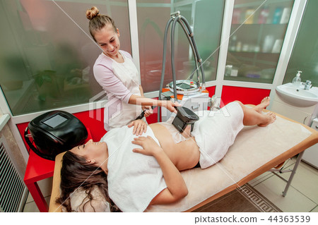 Woman getting cryolipolysis fat treatment 44363539