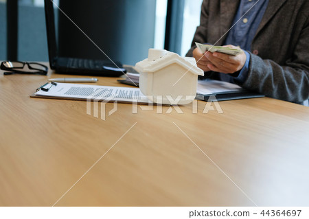 real estate agent realtor with house model dollar banknote & contract agreement. buying selling renting property real estate agent realtor with house model dollar banknote & contract agreement. buying selling renting property 44364697