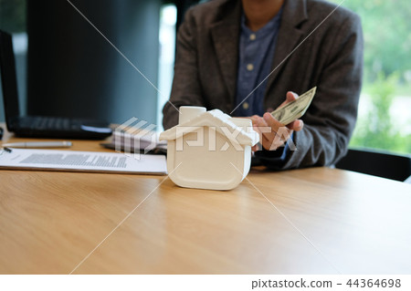 real estate agent realtor with house model dollar banknote & contract agreement. buying selling renting property 44364698