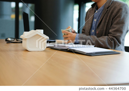 real estate agent realtor with house model & dollar banknote. buying selling renting property real estate agent realtor with house model & dollar banknote. buying selling renting property 44364700