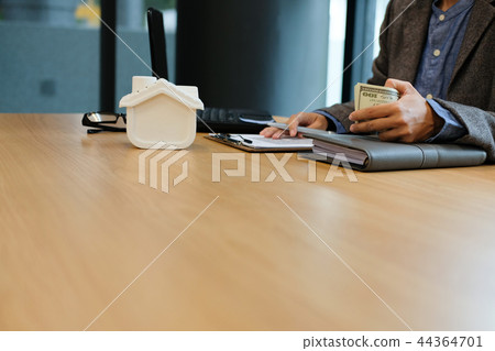 real estate agent realtor with house model dollar banknote & contract agreement. buying selling renting property 44364701