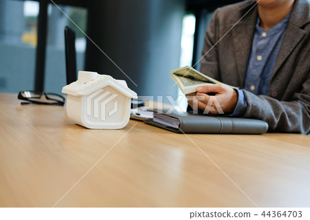 real estate agent realtor with house model & dollar banknote. buying selling renting property real estate agent realtor with house model & dollar banknote. buying selling renting property 44364703