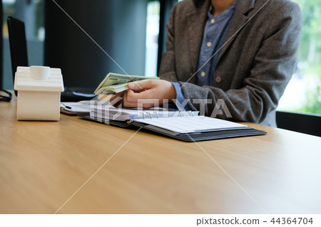 real estate agent realtor with house model & dollar banknote. buying selling renting property real estate agent realtor with house model & dollar banknote. buying selling renting property 44364704