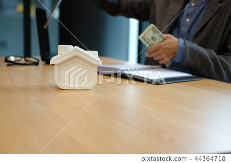 real estate agent realtor with house model & dollar banknote. buying selling renting property real estate agent realtor with house model & dollar banknote. buying selling renting property 44364718