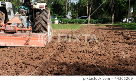farmer in tractor preparing field for seedling. agriculture work at farmland farmer in tractor preparing field for seedling. agriculture work at farmland 44365209