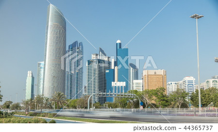 Corniche boulevard beach park along the coastline in Abu Dhabi timelapse with skyscrapers on background. 44365737