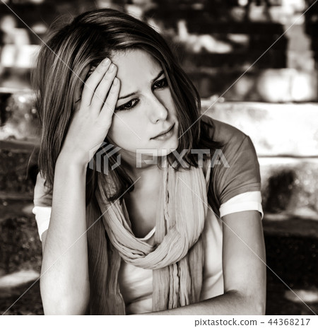Sad girl at garden. 44368217