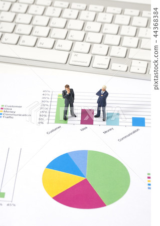 Miniature businessman with graphs 44368384