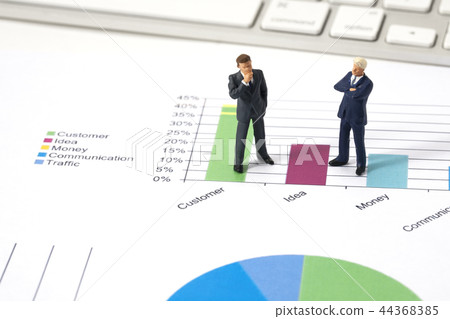 Miniature businessman with graphs Miniature businessman with graphs 44368385