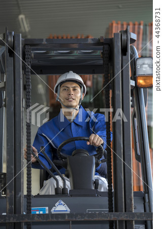 Male worker operating a forklift Male worker operating a forklift 44368731