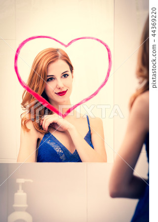 girl near mirror with heart it in bathroom. girl near mirror with heart it in bathroom. 44369220