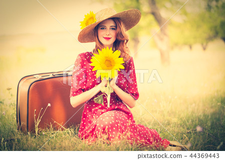 Redhead girl with sunflower at outdoor. 44369443