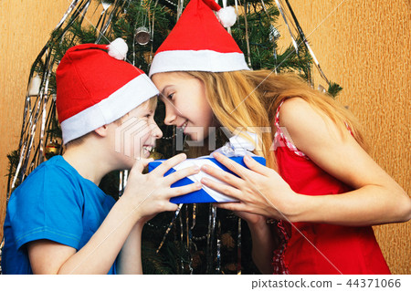 Teenagers siblings jokingly trying to snatch each other's Christmas gift Teenagers siblings jokingly trying to snatch each other's Christmas gift 44371066