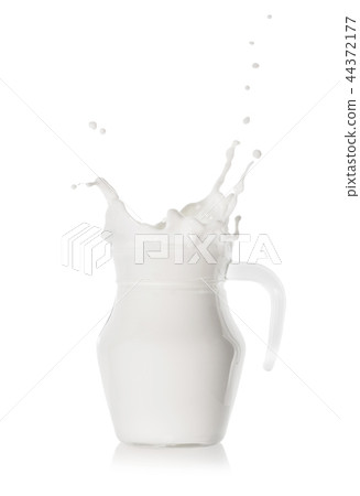 Splash of fresh white milk in a glass modern jug 44372177