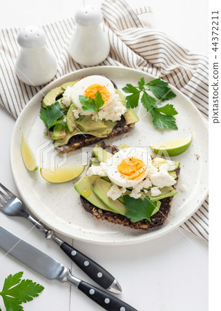 Wholegrain toast with avocado, egg and soft cheese 44372211