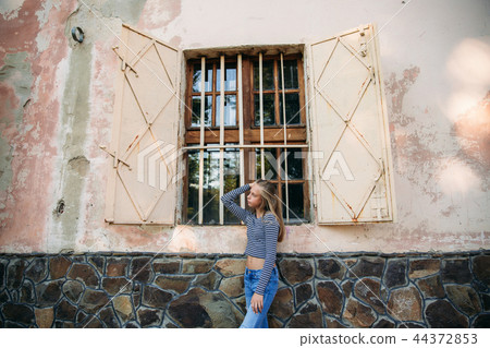 blonde teenage girl in striped blouse on the backgrountd of green tree 44372853