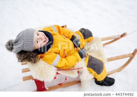 Little boy enjoying a sleigh ride 44374492