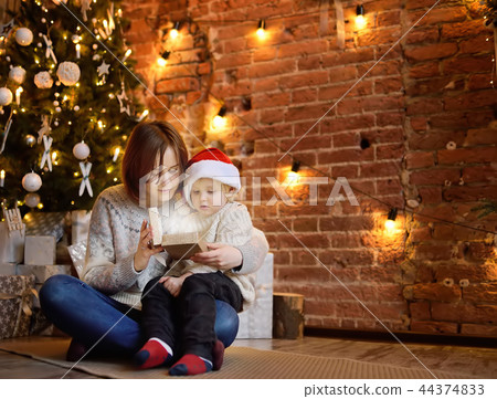 Mother with her little son reading a magic book in cozy living room. Family time on holidays Mother with her little son reading a magic book in cozy living room. Family time on holidays 44374833