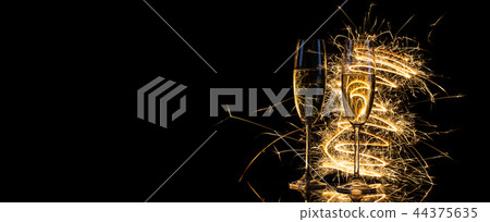 Glasses with champagne in the golden light of Bengal lights 44375635
