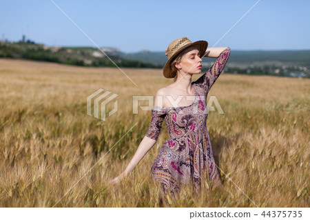 a woman farmer in field of wheat before the harvest 44375735