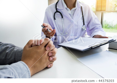 patient listening intently to a male doctor explaining patient s 44379203