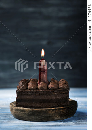bloody middle finger with a lit wick on a cake 44379488