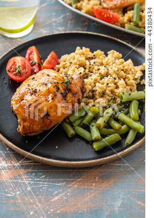 Grilled chicken thighs with bulgur, asparagus beans and tomatoes. Delicious lunch. Copy space. 44380434