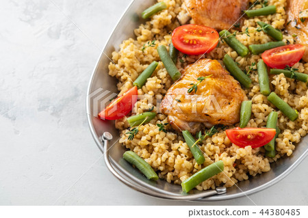 Grilled chicken thighs with bulgur, asparagus beans and tomatoes. Delicious lunch. 44380485