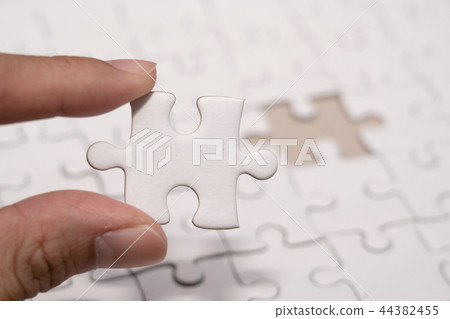 hand with last piece of Jigsaw puzzles hand with last piece of Jigsaw puzzles 44382455