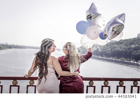 Positive joyful stylish women hugging each other 44383041