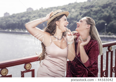 Positive joyful women standing on the bridge Positive joyful women standing on the bridge 44383042