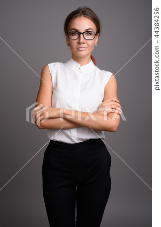 Young beautiful businesswoman against gray background 44384256