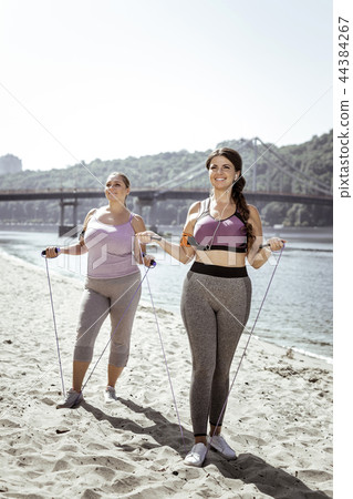 Positive joyful women holding their jumping ropes 44384267