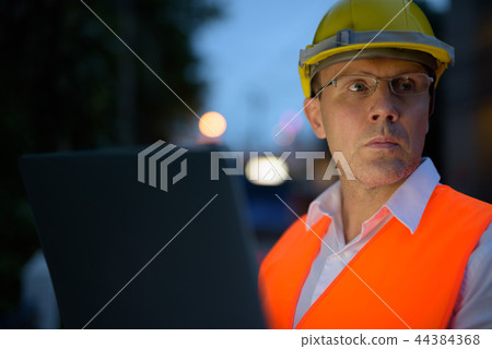 Mature man construction worker at the construction site in the c Mature man construction worker at the construction site in the c 44384368