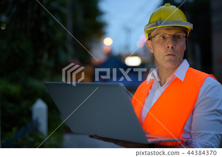 Mature man construction worker at the construction site in the c Mature man construction worker at the construction site in the c 44384370