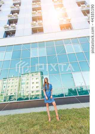 Fashion urban portrait of beautiful model on the street. Young slim woman wearing blue dress in the 44385190