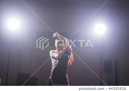 Skillful dancers performing in the dark room under the concert light and smoke. Sensual couple Skillful dancers performing in the dark room under the concert light and smoke. Sensual couple 44385816