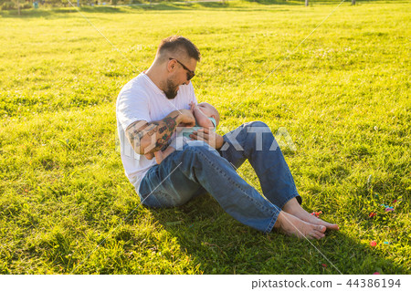 Happy father holding baby son on nature. Concept of happy family, father's day and child. Happy father holding baby son on nature. Concept of happy family, father's day and child. 44386194
