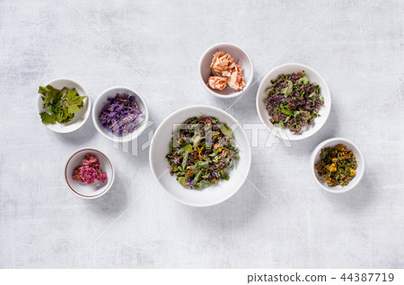 Mix of dry healthy herbs in the white plates 44387719