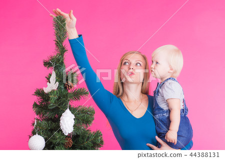Christmas, holidays and people concept - young happy woman with her daughter on hands show Christmas, holidays and people concept - young happy woman with her daughter on hands show 44388131