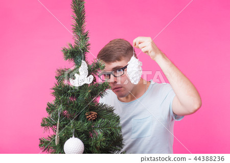 Christmas, holidays and people concept - young happy man show christmas decorations on christmas 44388236